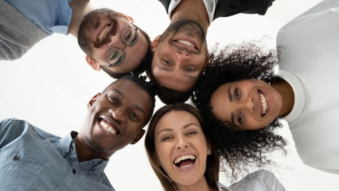 fünf Menschen blicken gemeinsam von oben in die Kamera